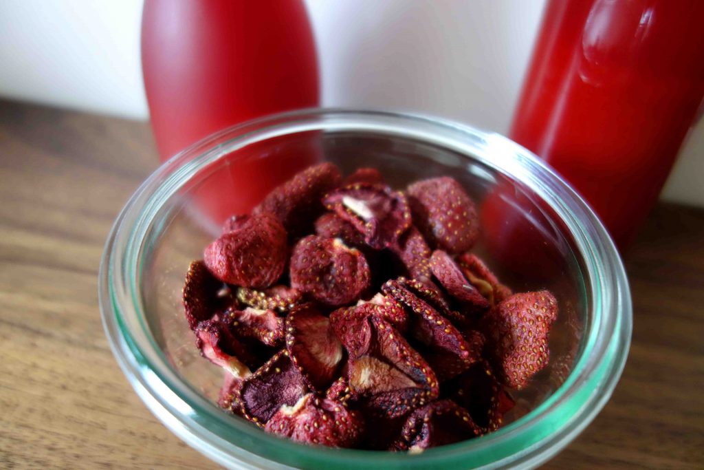 Erdbeersirup und getrocknete Erdbeeren